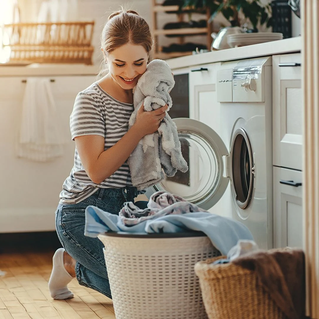 Woman folding freshly laundered clothes on a kitchen countertop