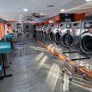 Commercial laundry room with multiple washing machines and utility sink at 4th Street Laundromat