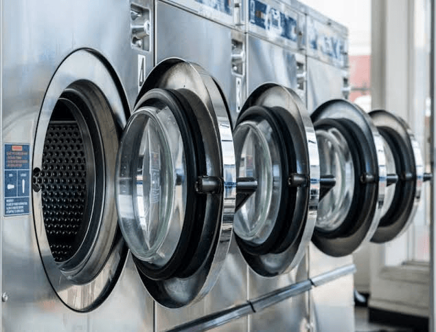 Row of commercial washing machines in a professional laundry facility